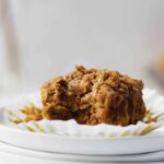 pumpkin oatmeal muffin on plate with bite taken out of it