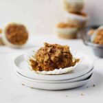 pumpkin oatmeal muffin on stacked plates with muffins in background