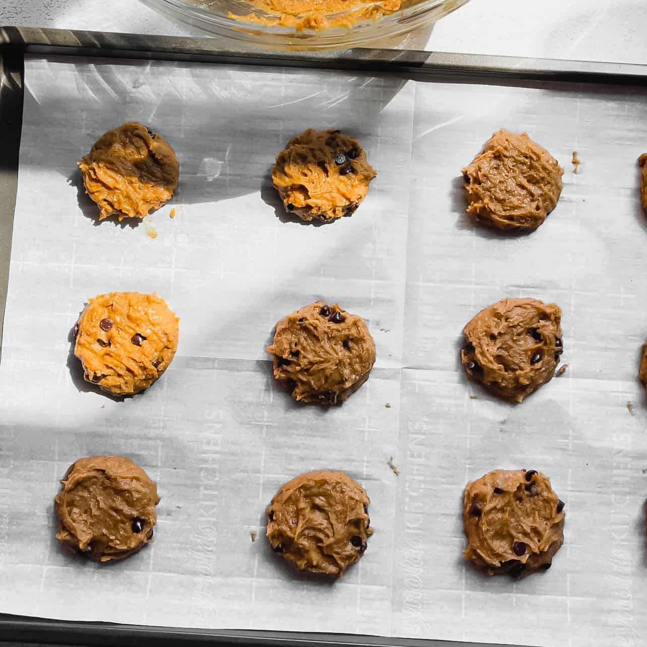 cookie dough on baking sheet for The Best Soft Pumpkin Chocolate Chip Cookies (Vegan, Gluten-Free)